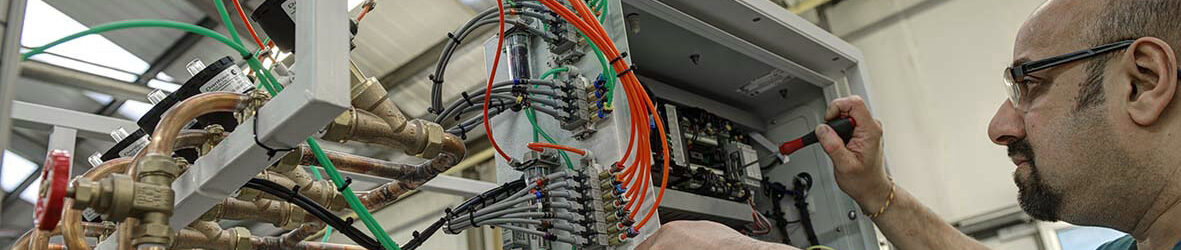 A technician wiring up a circuit board